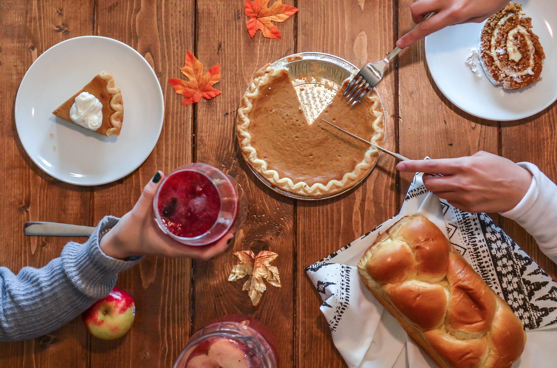 Pumpkin pie being sliced onto plates