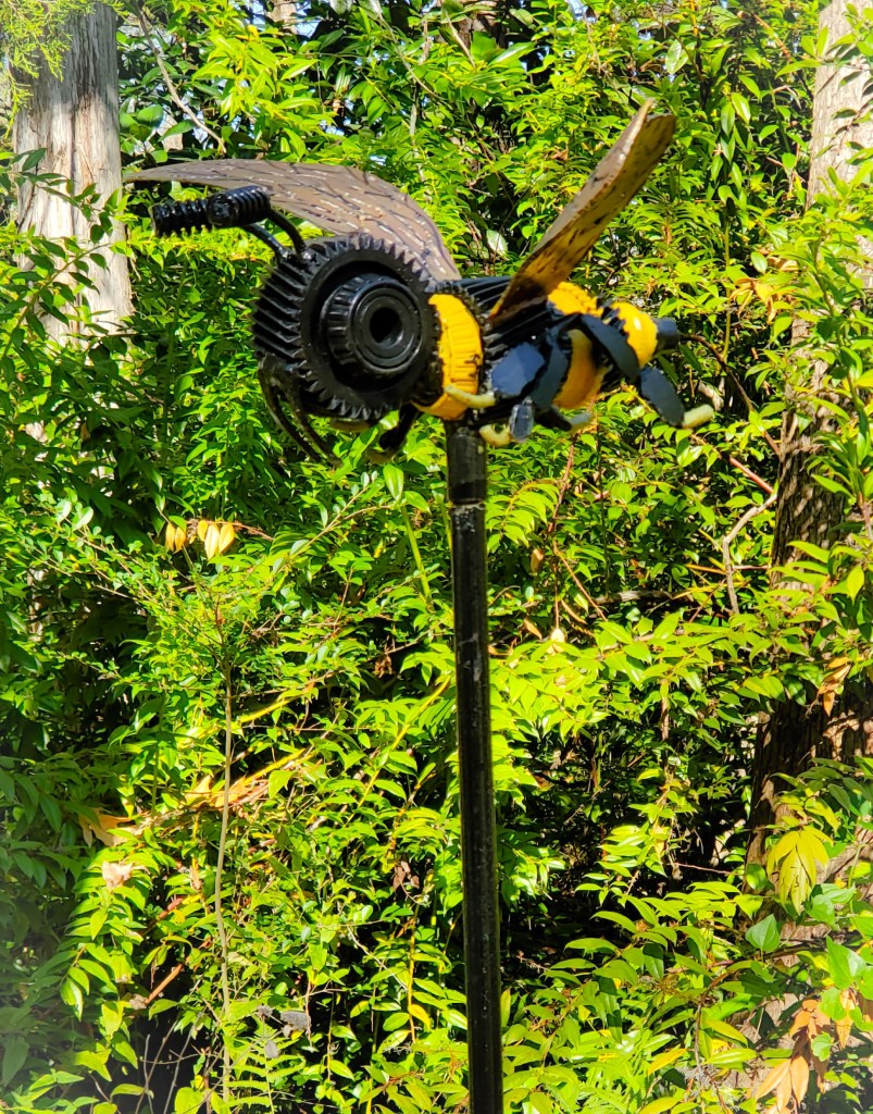 yellow and black metal bee on a pole