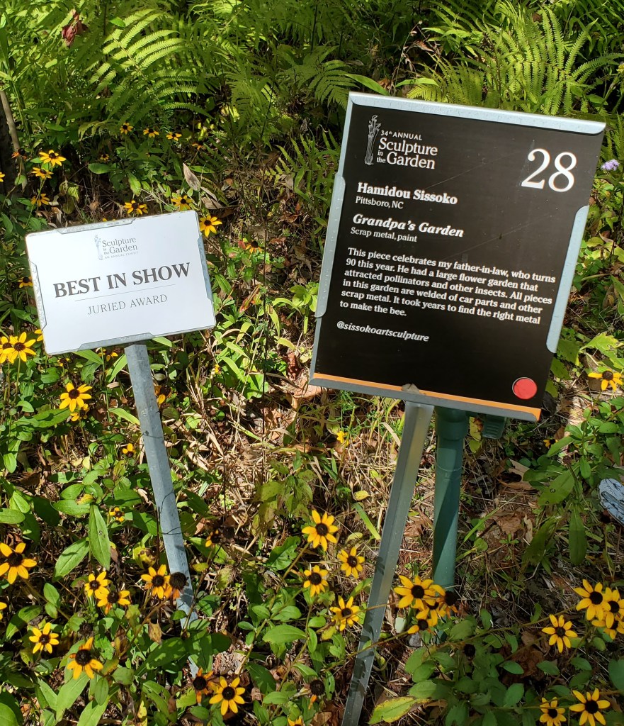 Sign that describes the art Grandpa's Garden in the artist's words and sign that reads "Best in Show," Juried Award.