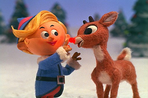 Hermey, the elf, is touching Rudolph's red nose.